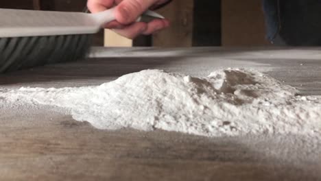 White-powder-being-swept-on-and-off-of-a-wooden-table