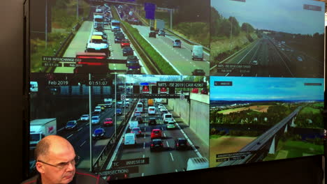 Four-CCTV-video-screens-in-a-control-room-showing-traffic-conditions-with-operator