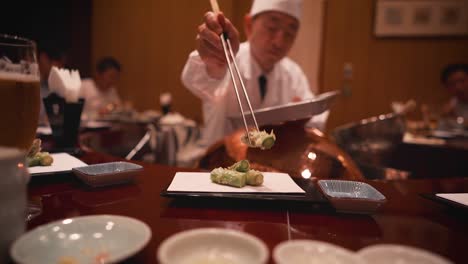 Chef-of-Tokyo-tempura-restaurant-serves-fried-asparagus-with-chopsticks-in-slow-motion-to-customer