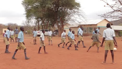 School-boys-playing-football-in-a-dry-area,-Kenya-Africa