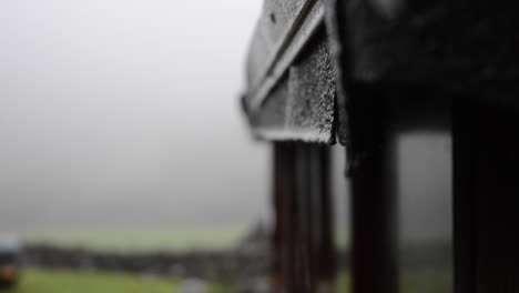 water-drips-off-a-roof-in-the-rain-as-the-camera-shifts-focus