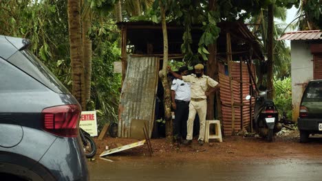 Indian-Police-Officer-Watches-Traffic-Leaning-on-Tree-Speaking-to-Local-Resident