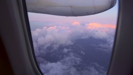 View-of-beautiful-sunset-above-the-clouds,-shot-from-a-plane-window
