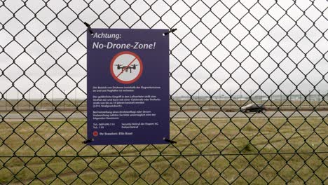 No-drone-zone-warning-sign-on-a-fence-at-an-airport