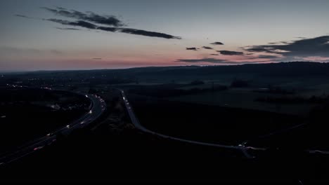 Drone-Aerial-Day-To-Night-Transition-Timelapse,-Sunset-and-Traffic-in-beautiful-Nature
