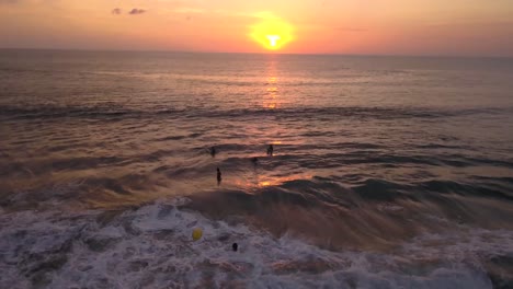 Drone-video-of-surfer-falling-of-the-board,-riding-a-wave-at-Canggu-Beach-at-sunset-in-Bali,-Indonesia