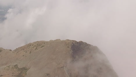 Clouds-and-weather-near-the-summit-of-a-mountain-as-a-drone-flies-overhead