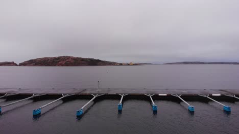 The-beautiful-dock-fingers-of-the-North-Harbor-Lysekil,-Sweden-with-mountains-in-the-background---aerial