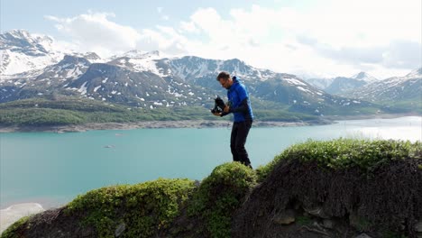 Zoomen-Sie-Auf-Den-Drohnenpiloten,-Der-Auf-Einem-Grasbewachsenen-Grat-Mit-Blick-Auf-Den-Mont-Cenis-See-In-Frankreich-Steht