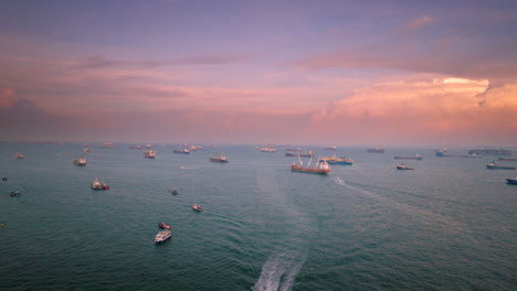 Luftaufnahme-Des-Sonnenuntergangs-über-Verstreuten-Containerschiffen-In-Der-Straße-Von-Singapur